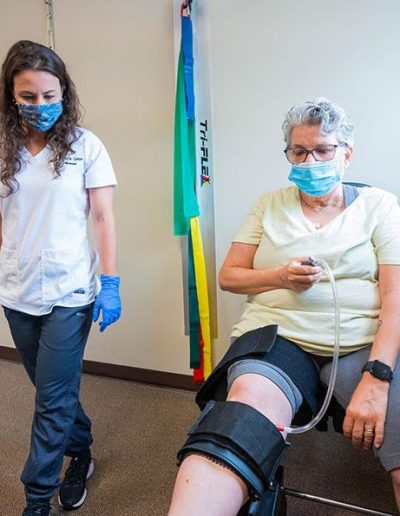 Dr Kayla with a client with her knee on trac.